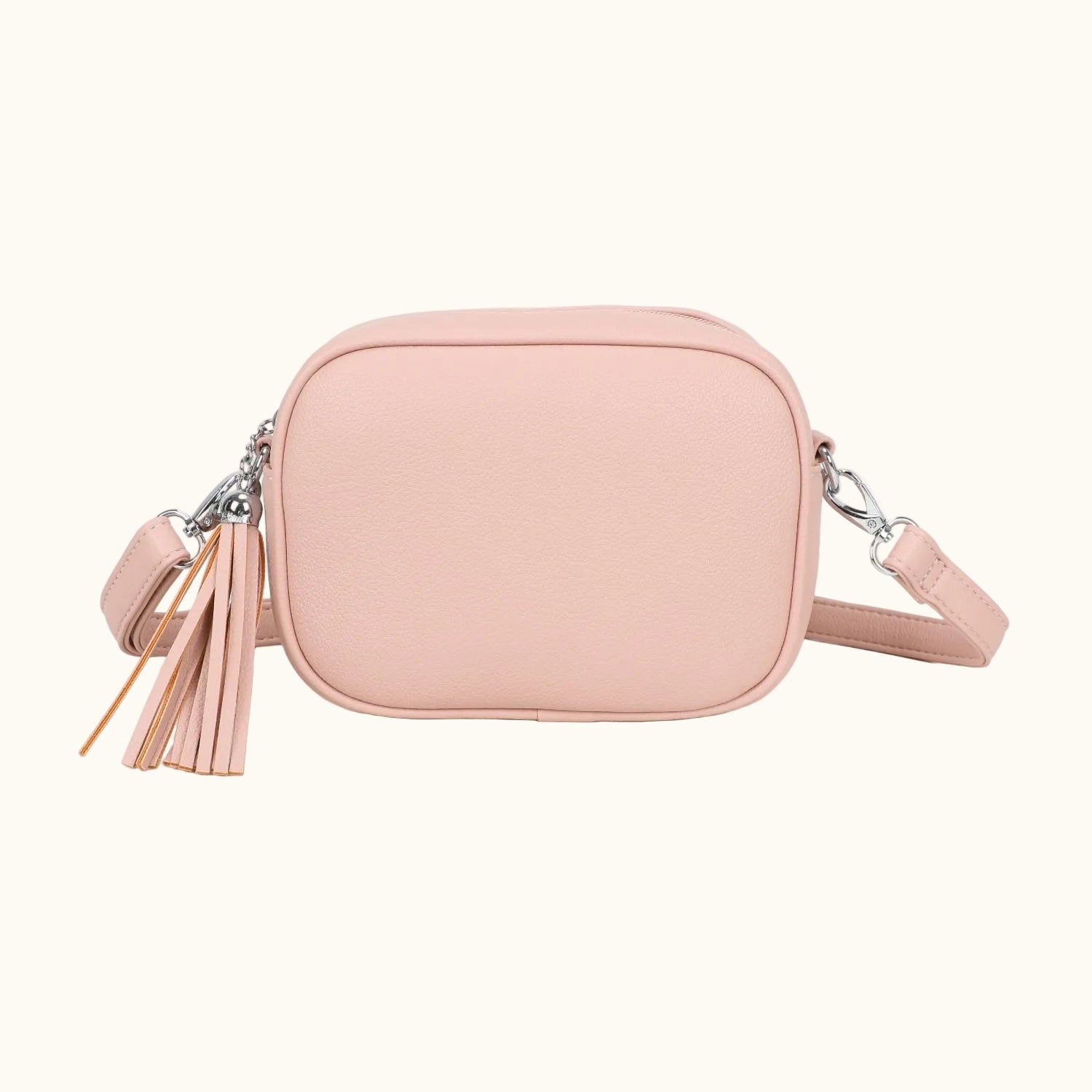 Pink crossbody bag with tassel on a white background