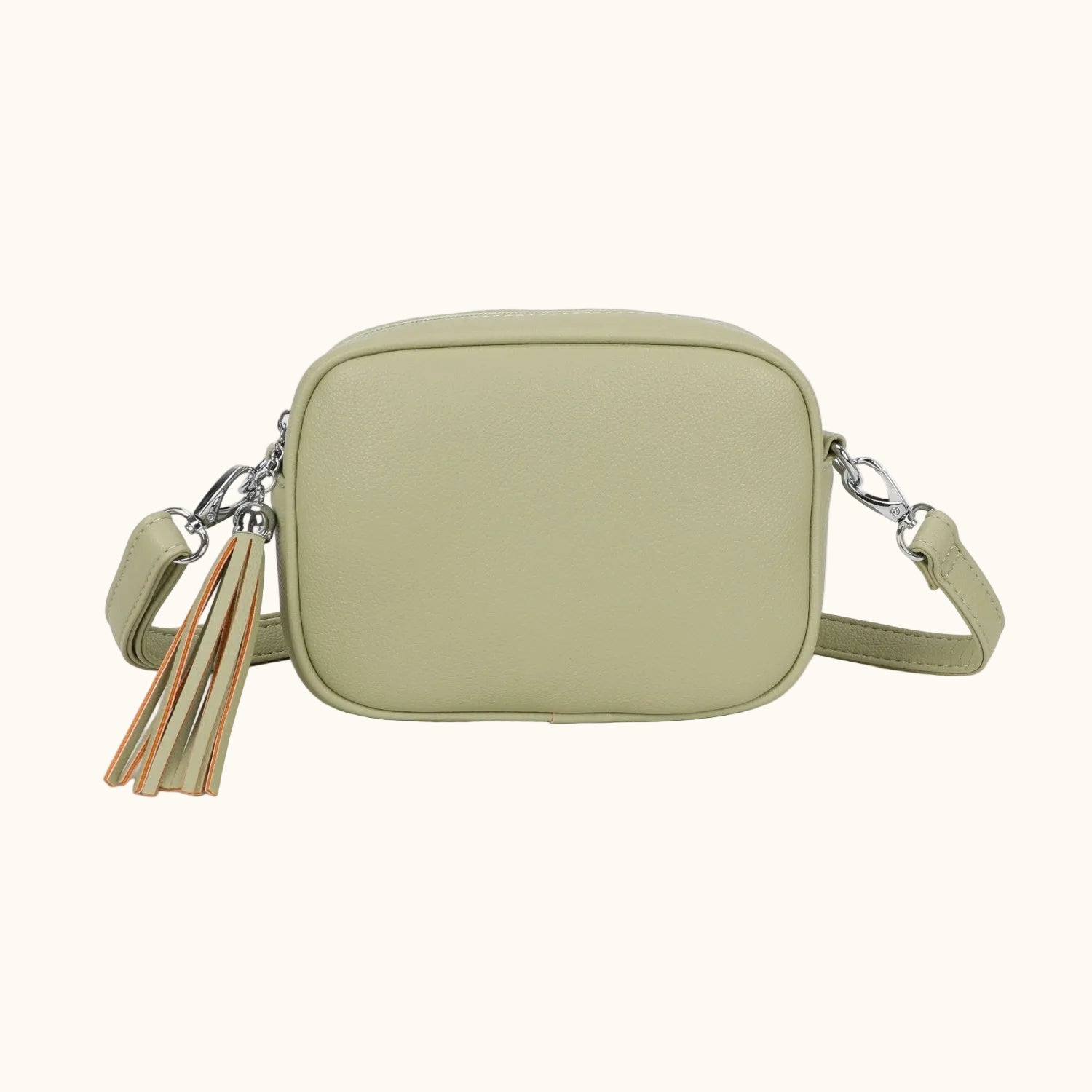 Green crossbody bag with tassel details on a white background