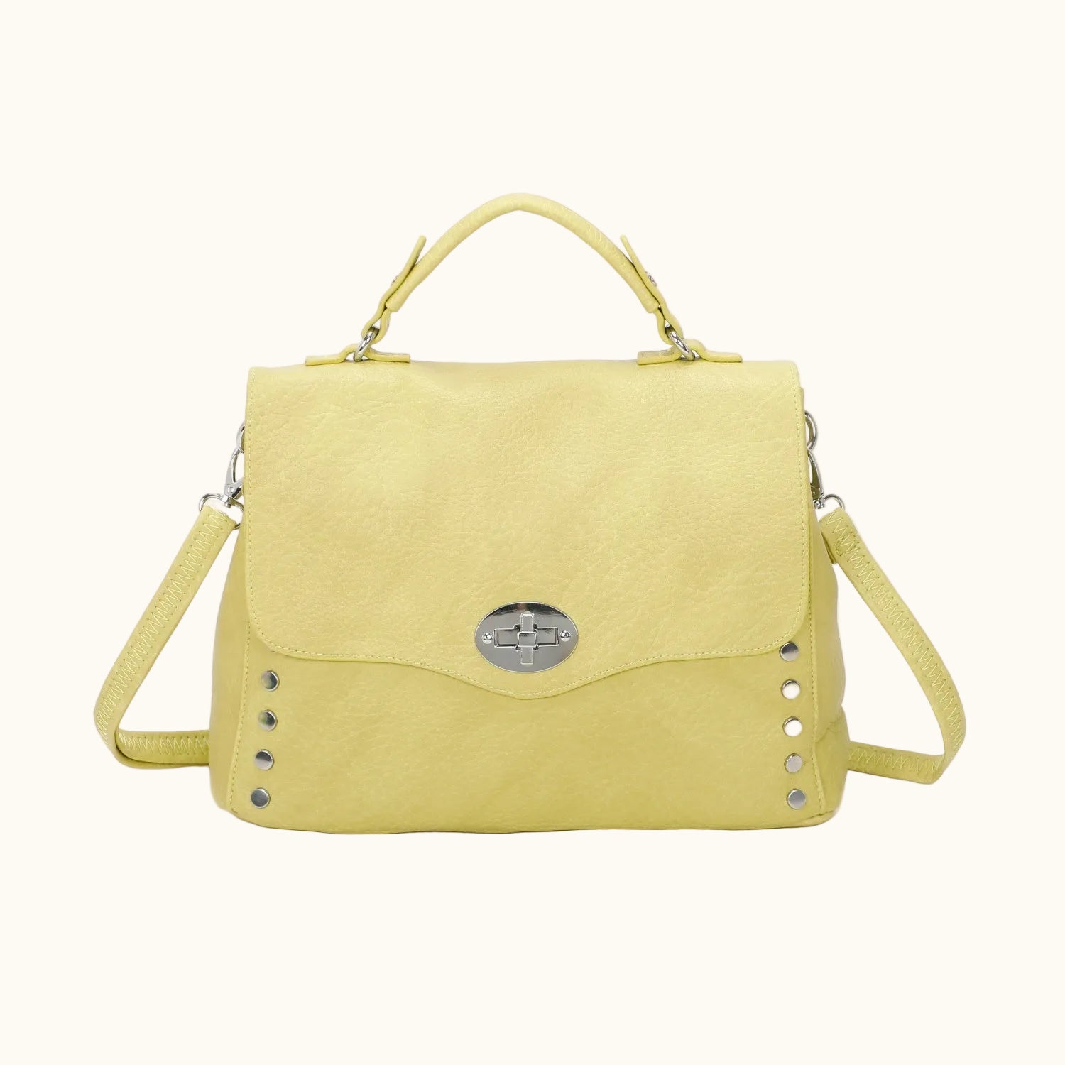 Yellow handbag with studded details on a white background