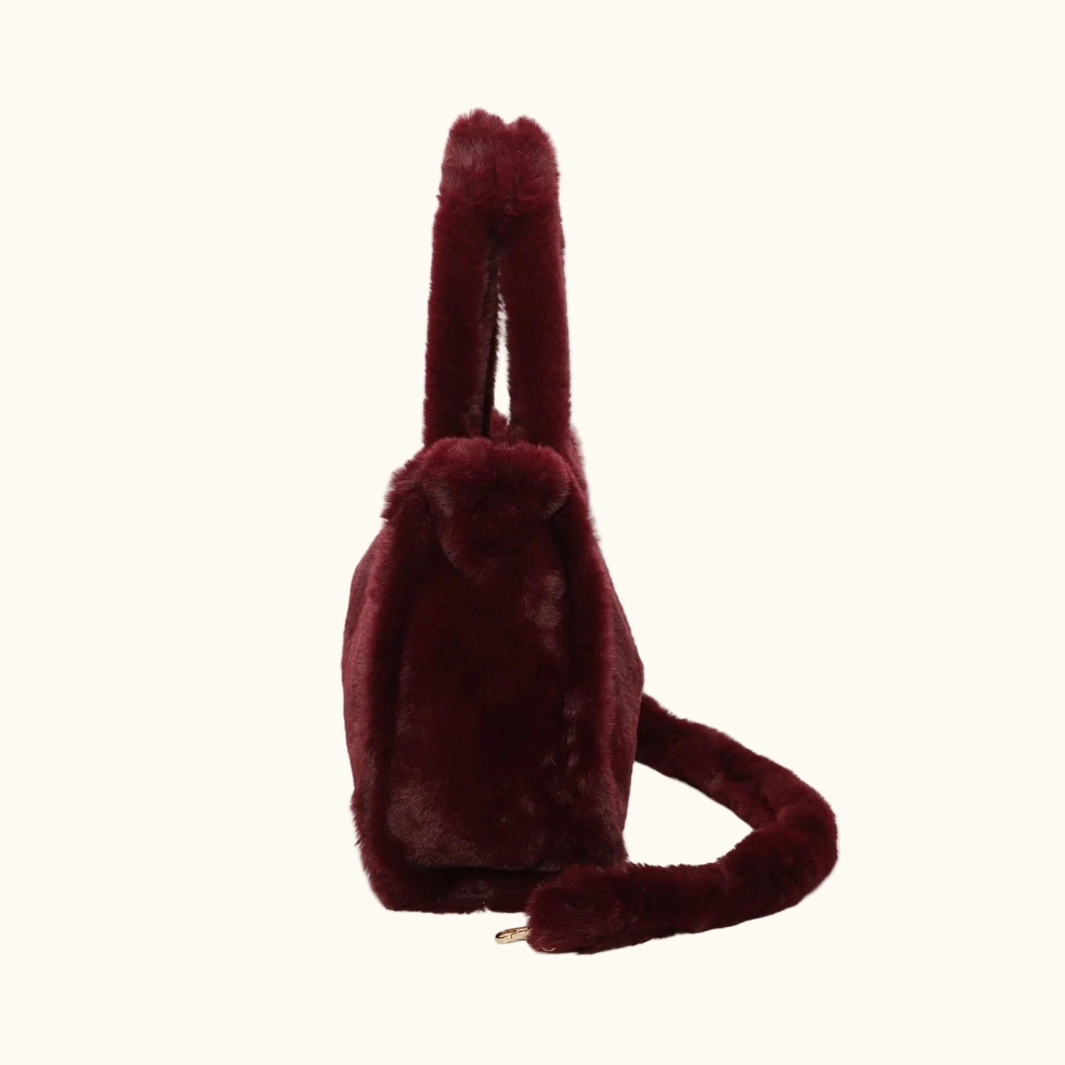 Maroon plush bag with a handle and strap on a white background