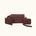 Brown leather tote bag with matching wallet and pouch on a white background