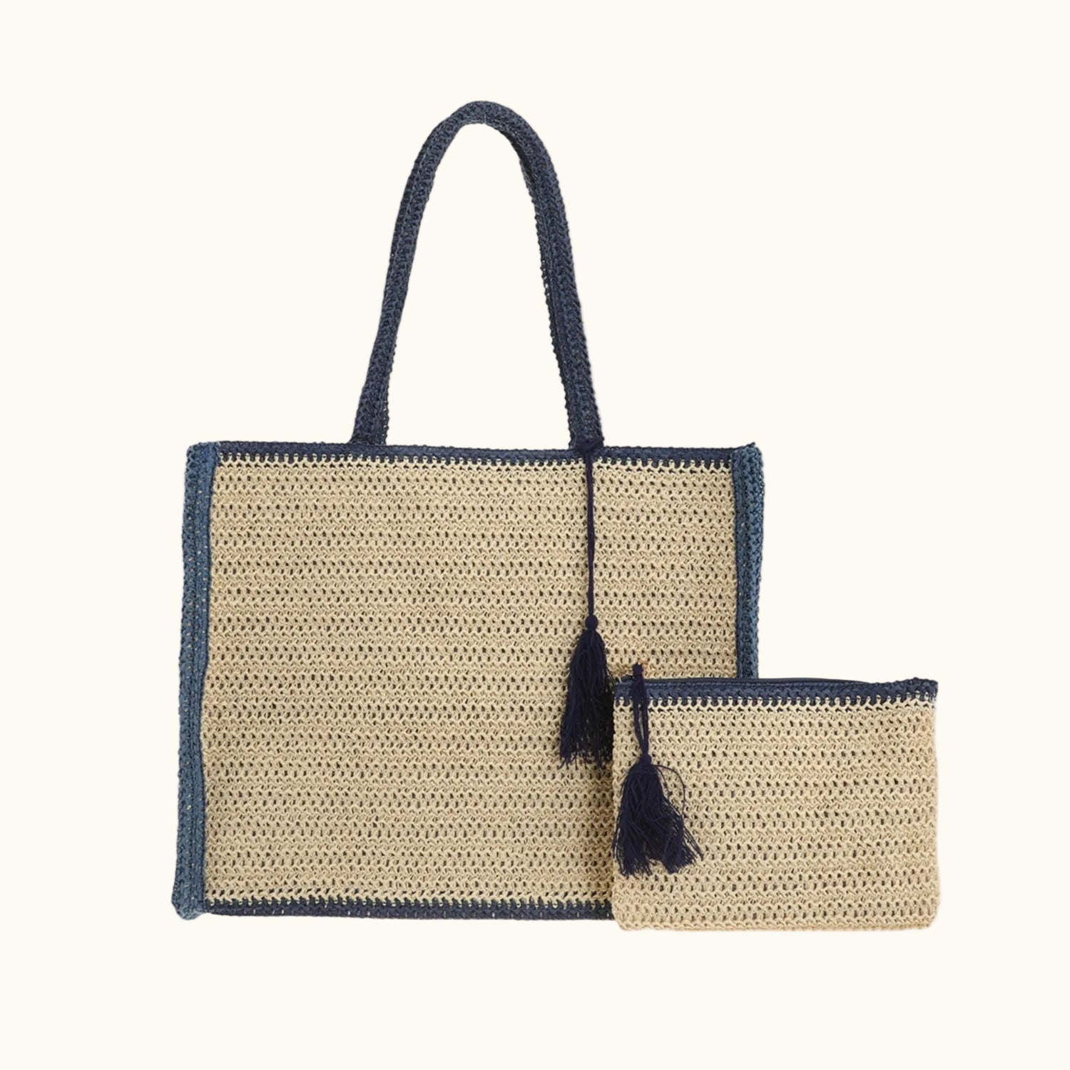 Woven handbag with navy accents and tassels on a white background