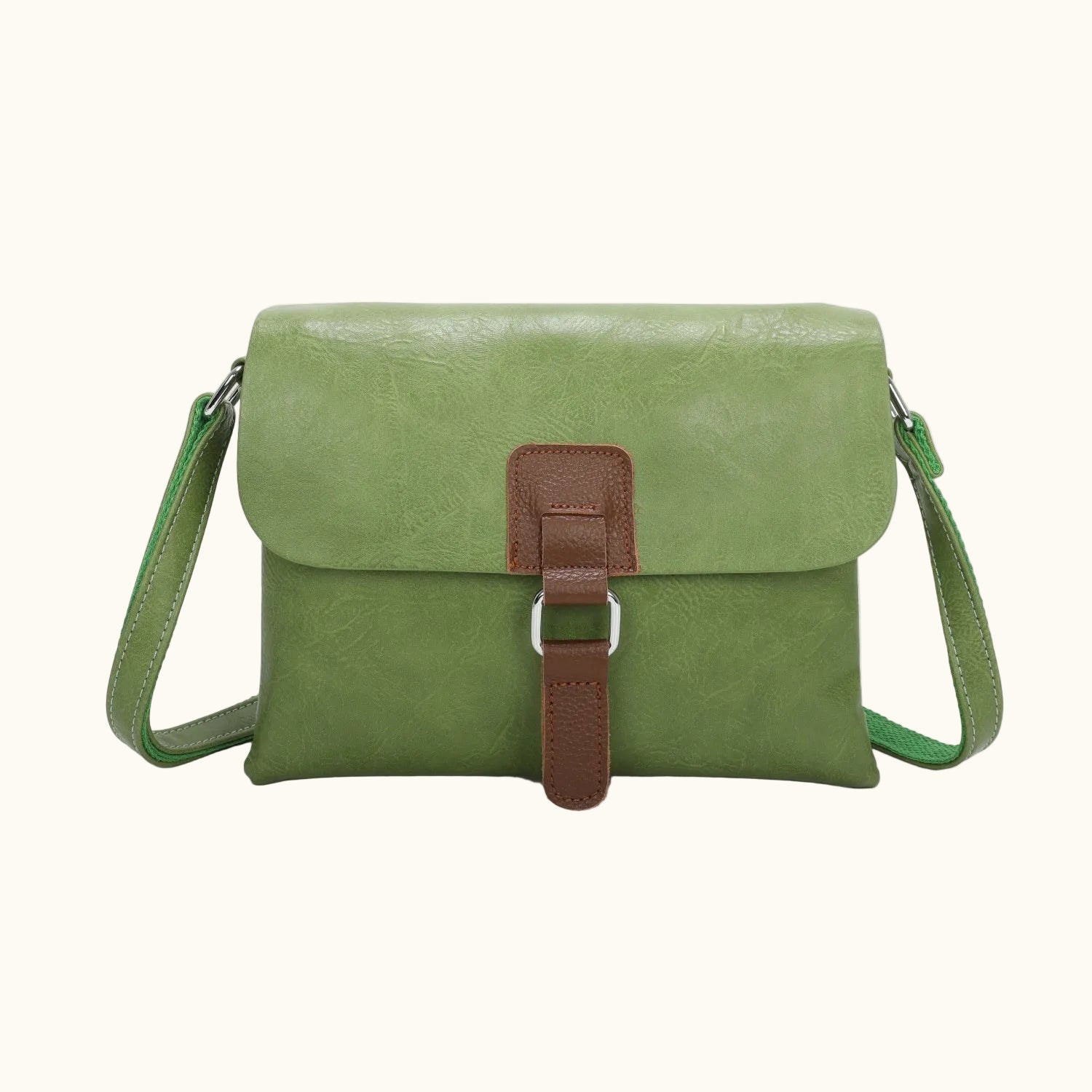 Green leather crossbody bag with a brown strap on a white background