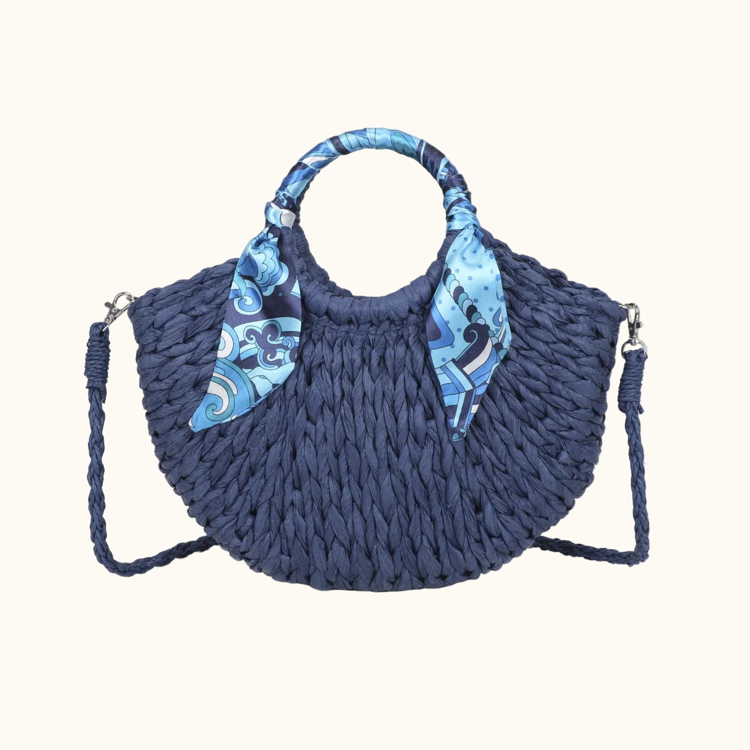 Blue woven handbag with decorative straps on a white background