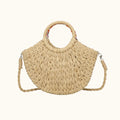 Beige woven handbag with a handle and crossbody strap on a white background