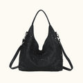 Black handbag with perforated design on a white background