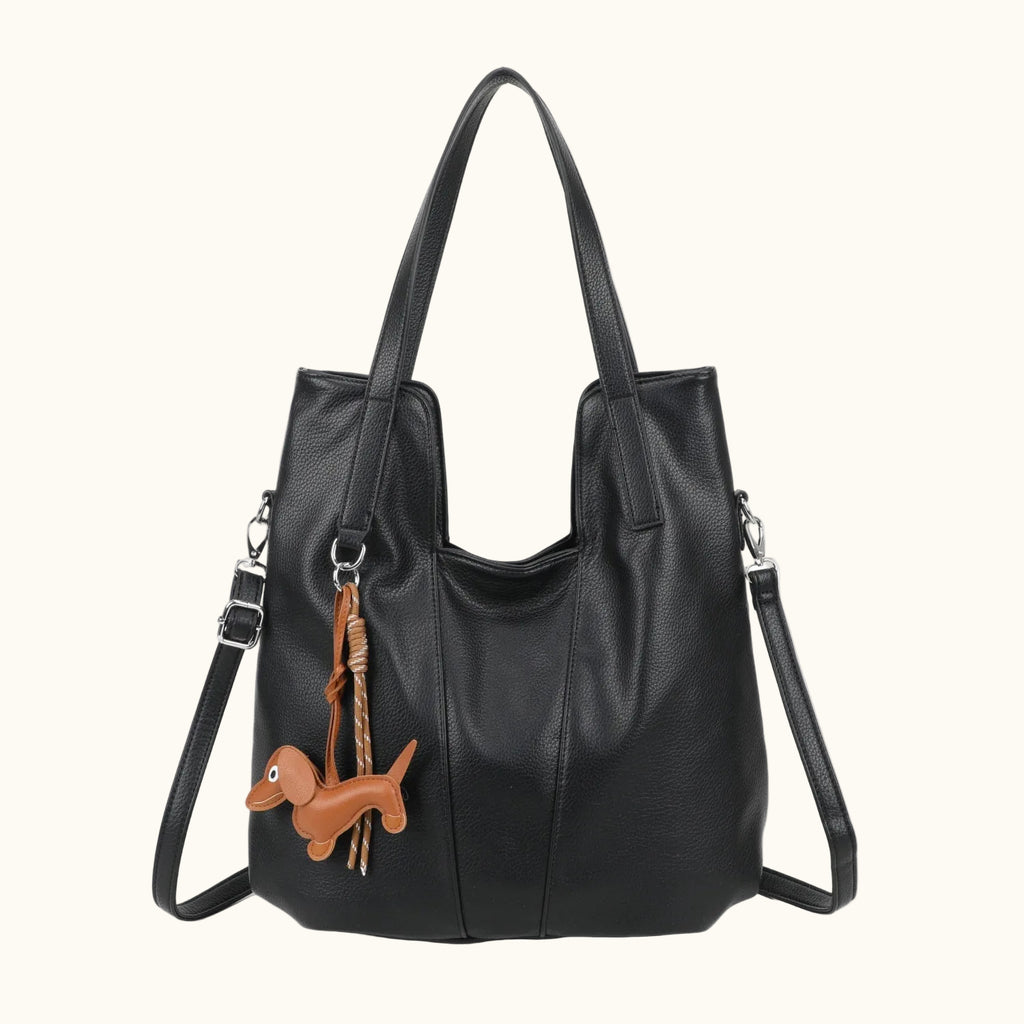 Black handbag with a dachshund charm on a white background