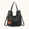 Black handbag with a dachshund charm on a white background
