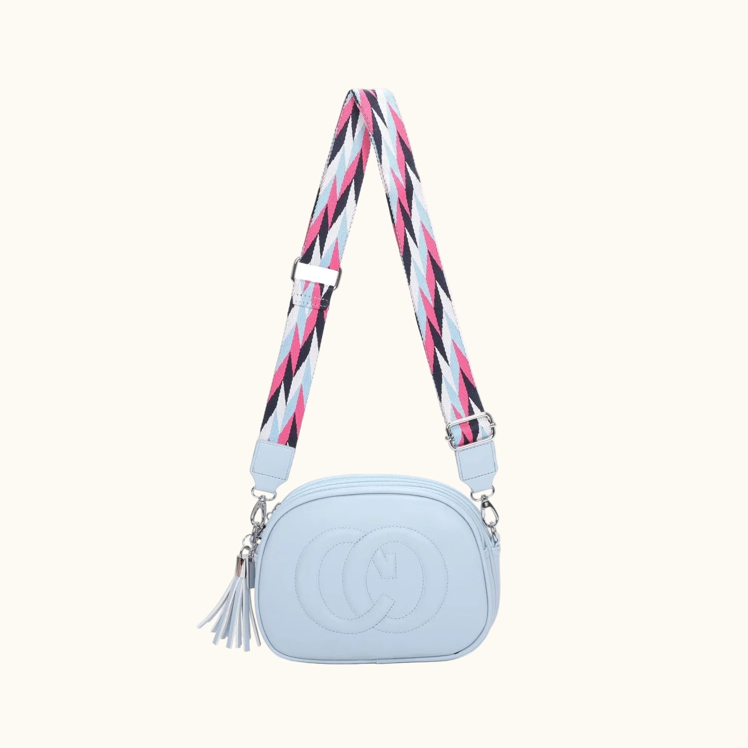 Light blue handbag with a colorful strap on a white background