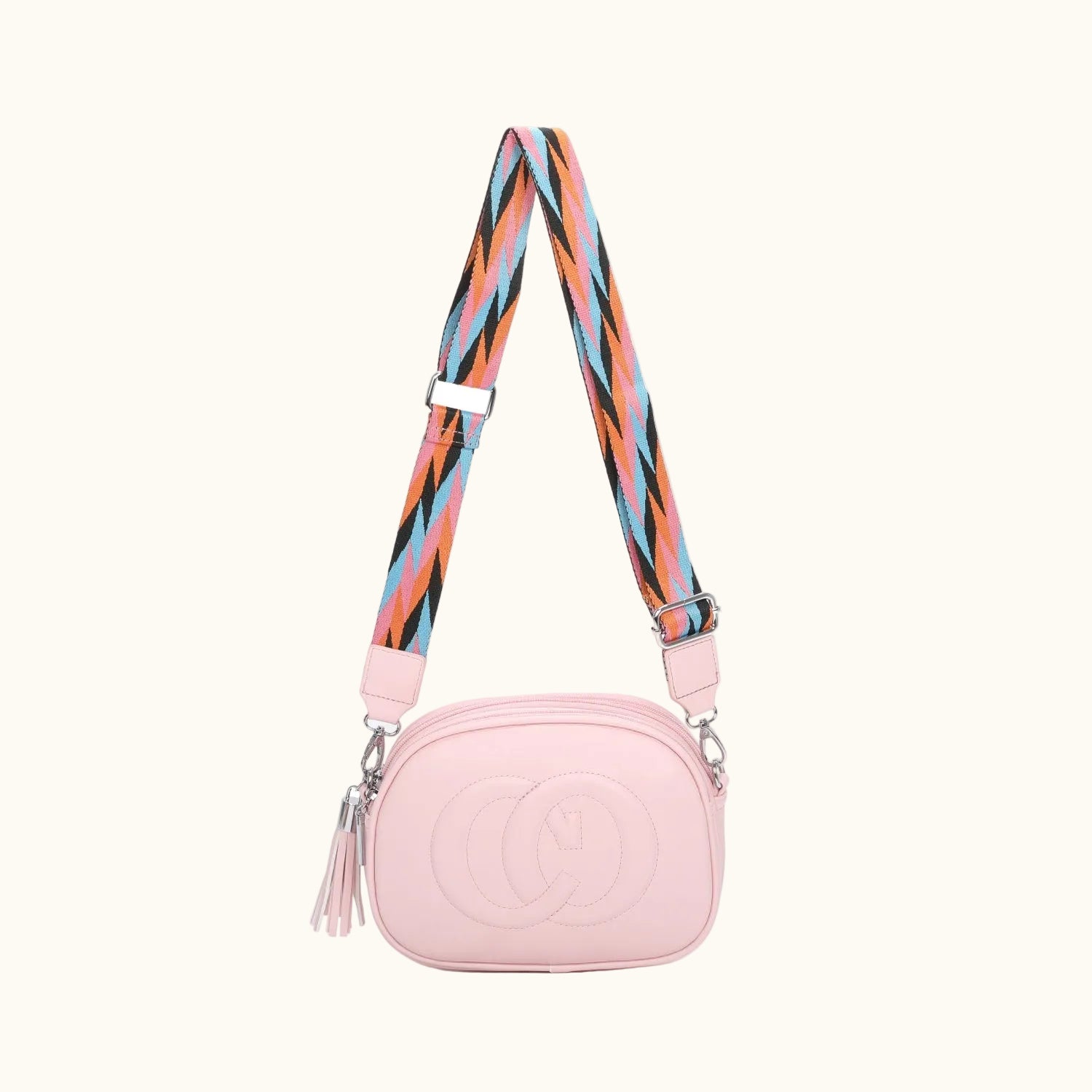Pink camera bag with a colorful strap on a white background