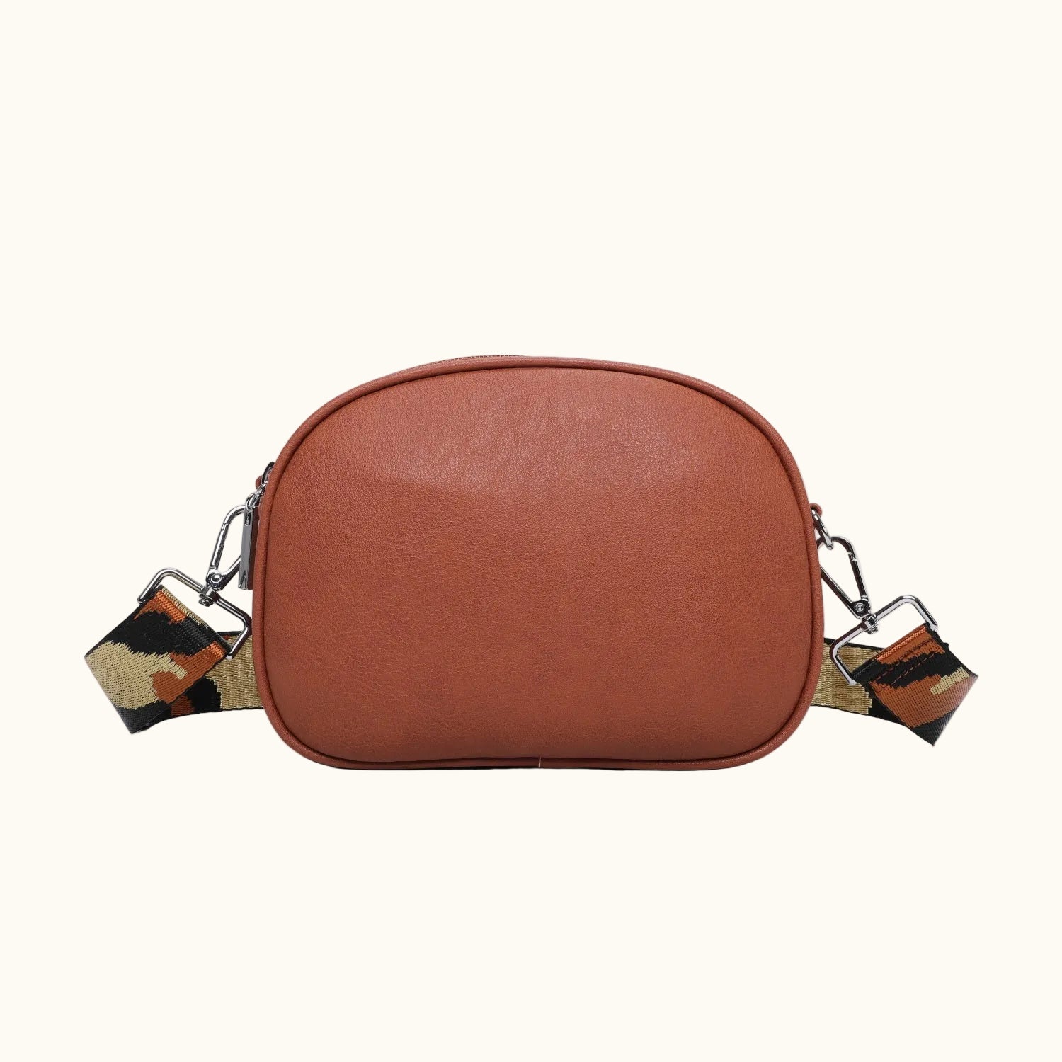 Brown leather crossbody bag with a patterned strap on a white background