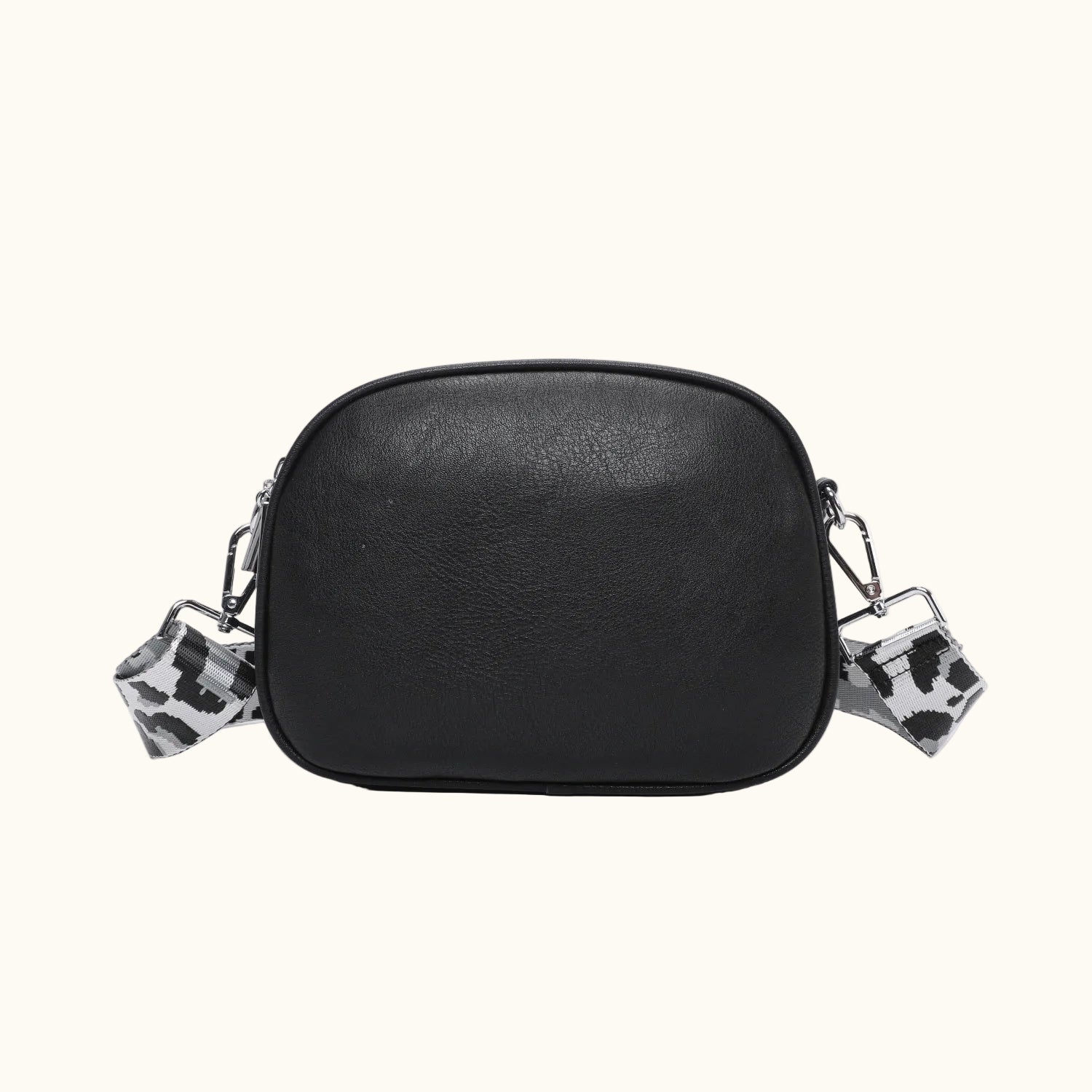 Black leather crossbody bag with leopard print charms on a white background
