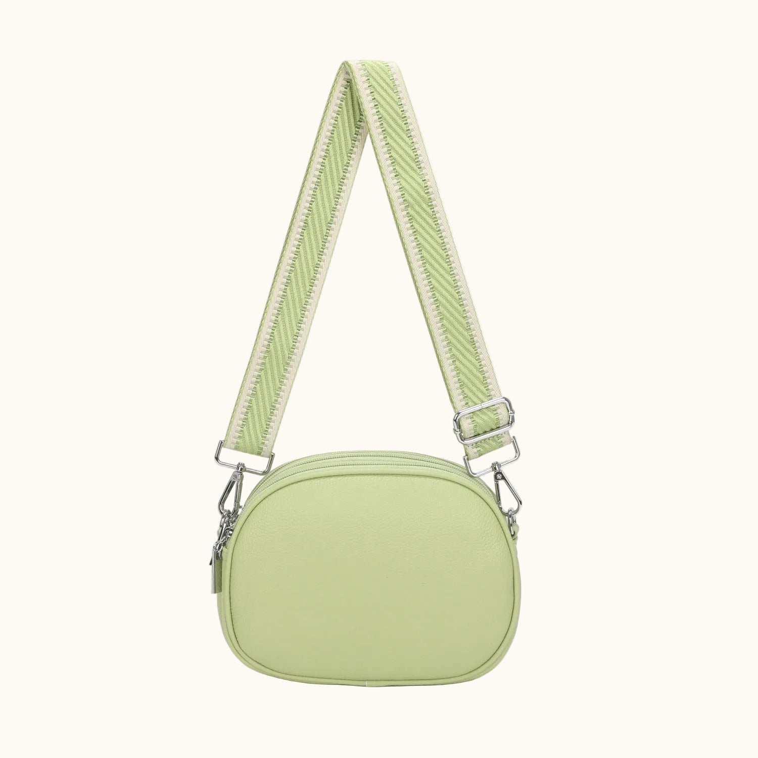 Light green crossbody bag with a strap on a white background