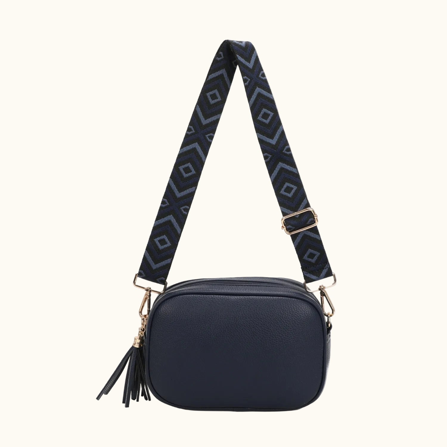 Navy blue crossbody bag with a patterned strap on a white background