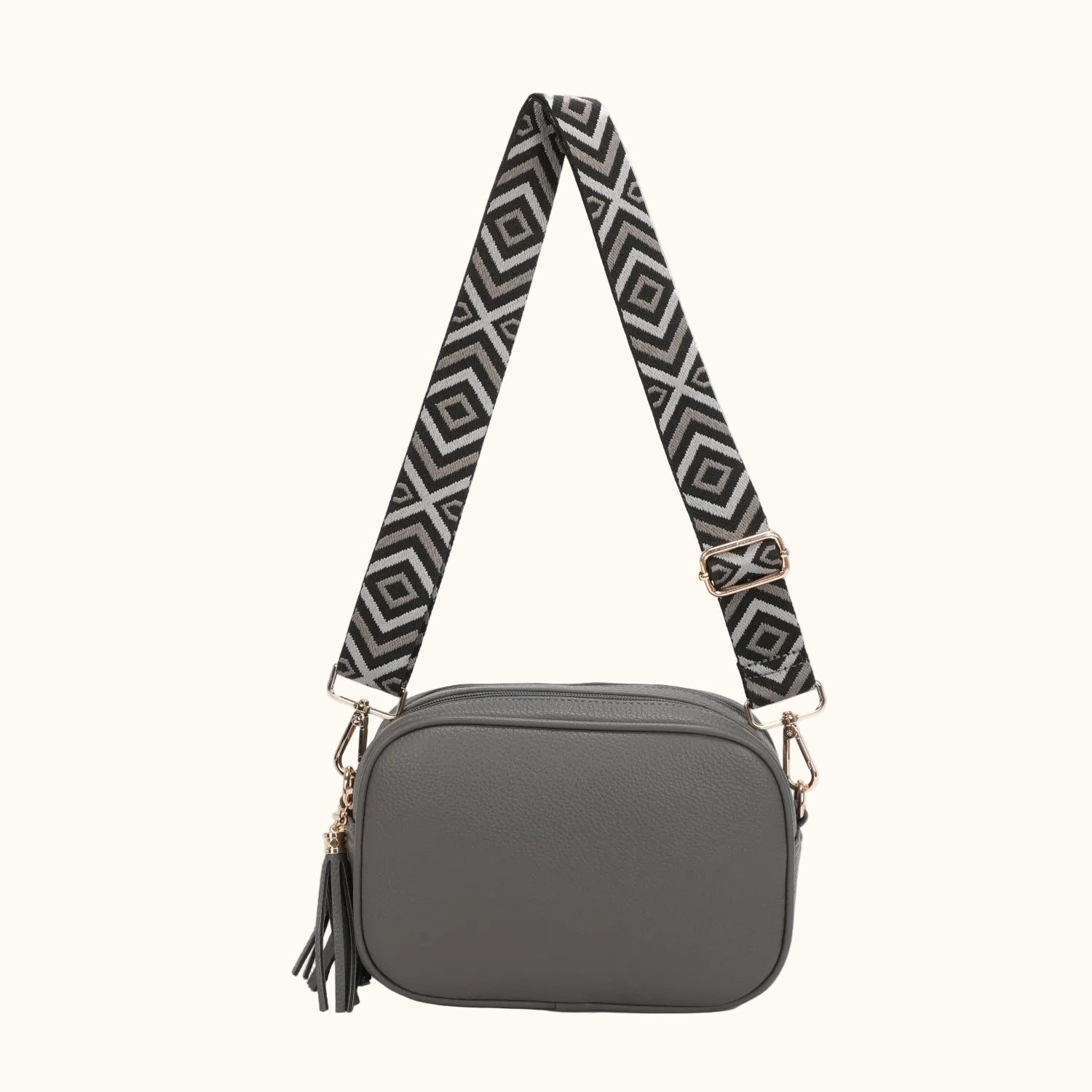 Gray crossbody bag with a patterned strap on a white background