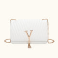 White handbag with a gold chain and letter 'Y' tassel on a white background
