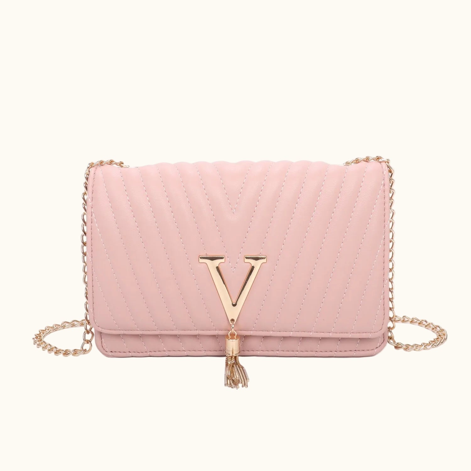 Pink handbag with gold chain and tassel on a white background