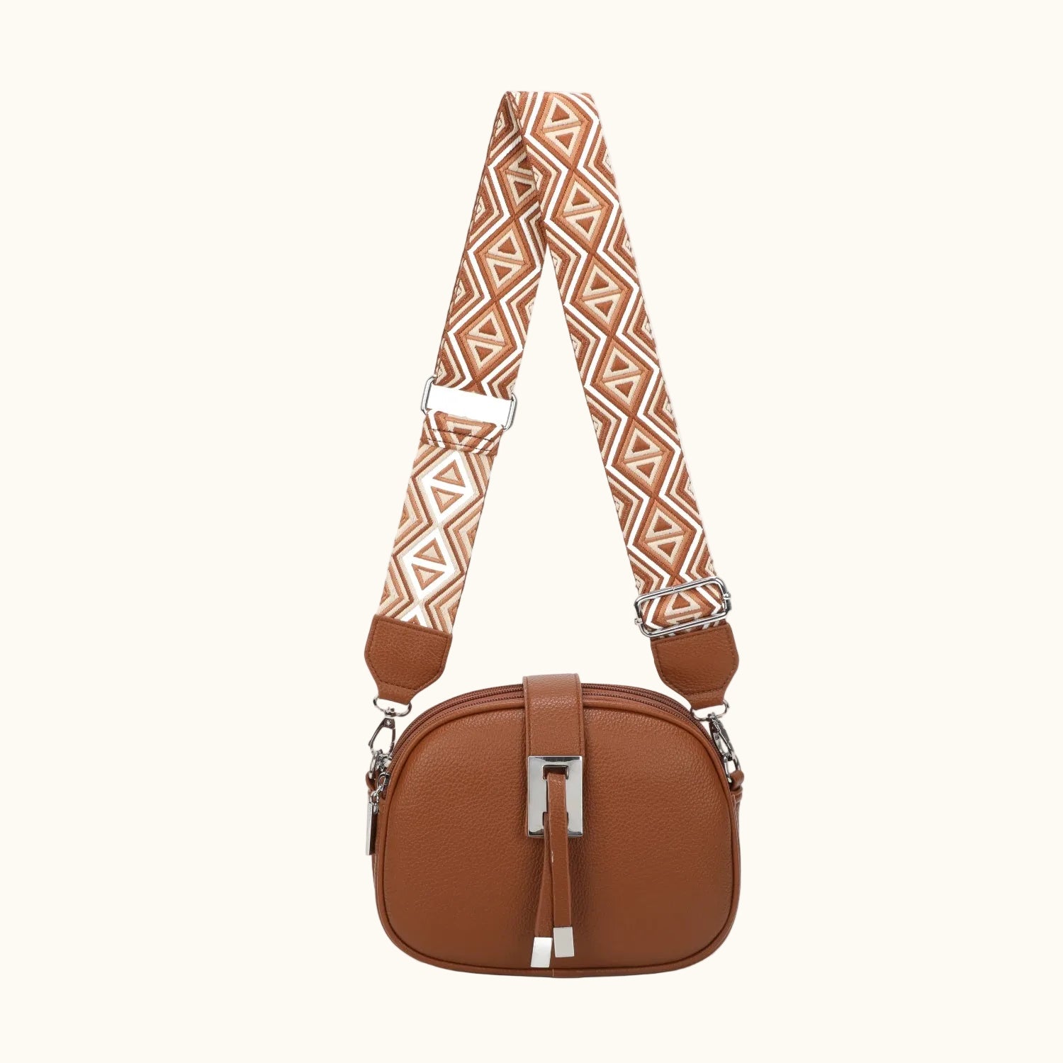Brown handbag with a patterned strap on a white background