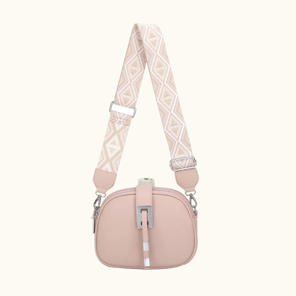 Pink handbag with a patterned strap on a white background