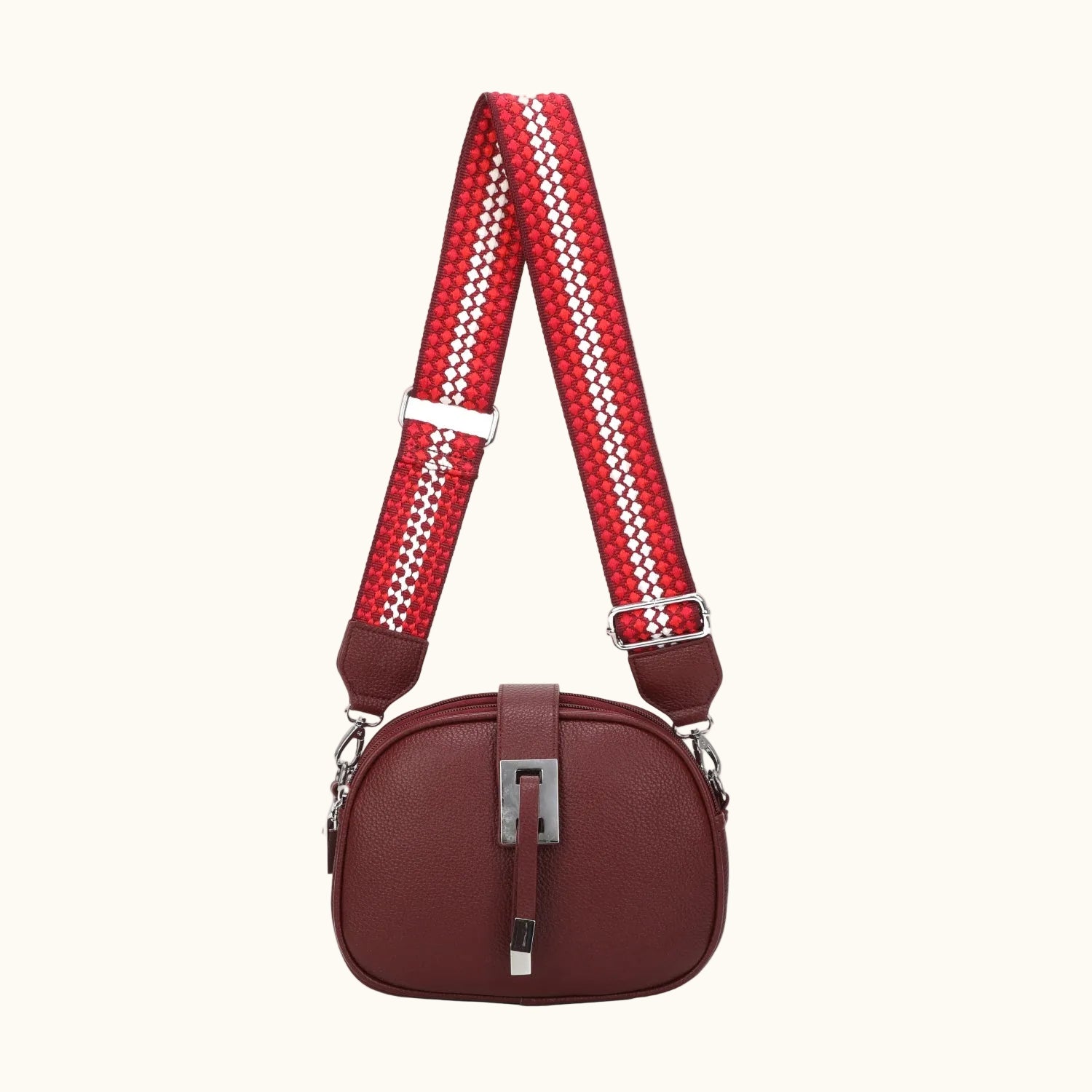 Red handbag with a patterned strap on a white background