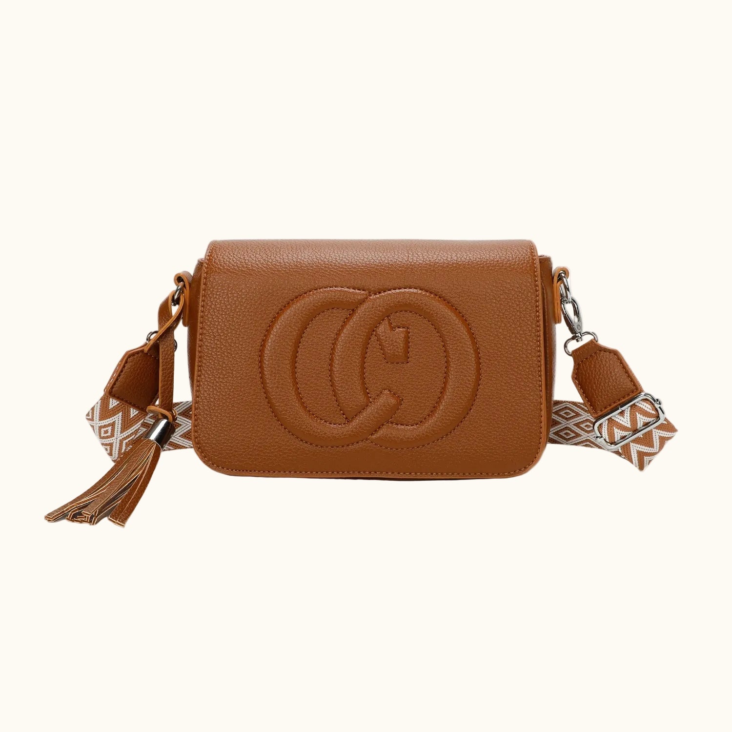 Brown leather crossbody bag with tassel on a white background