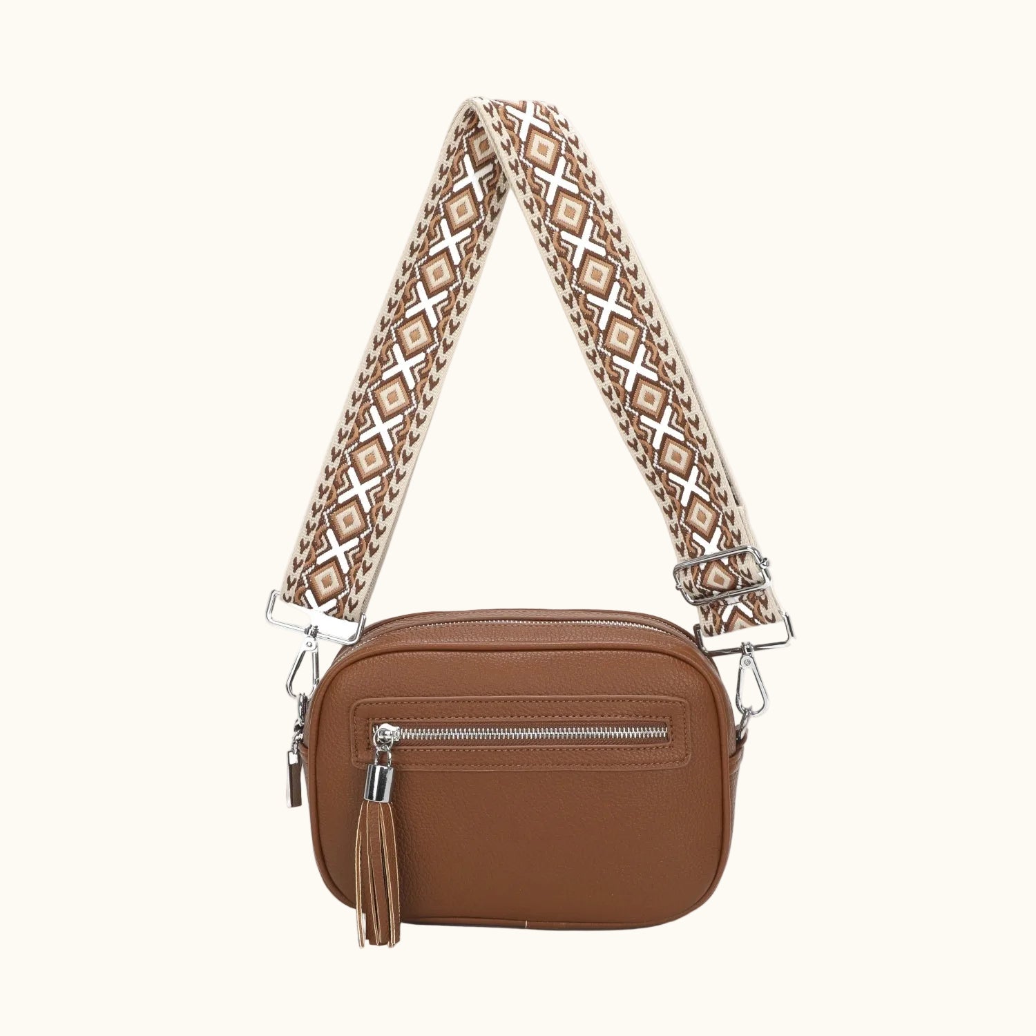 Brown leather camera bag with a patterned strap on a white background