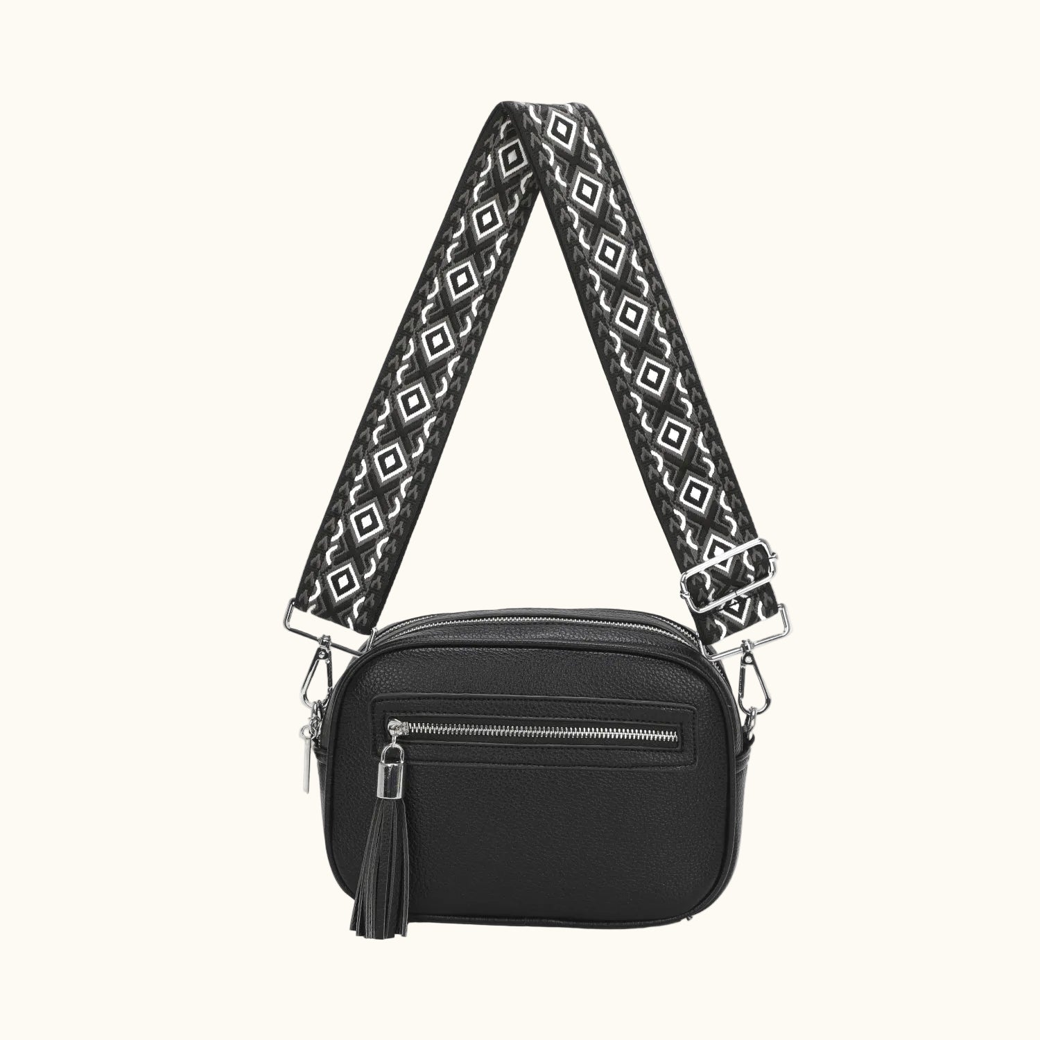 Black crossbody bag with a patterned strap on a white background