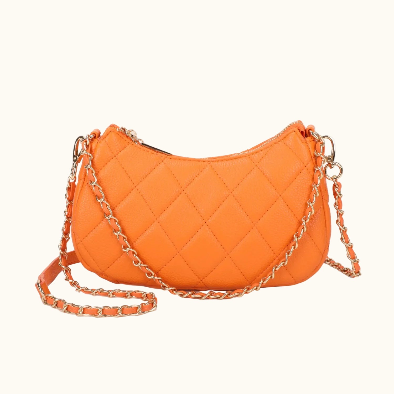 Orange quilted handbag with a chain strap on a white background