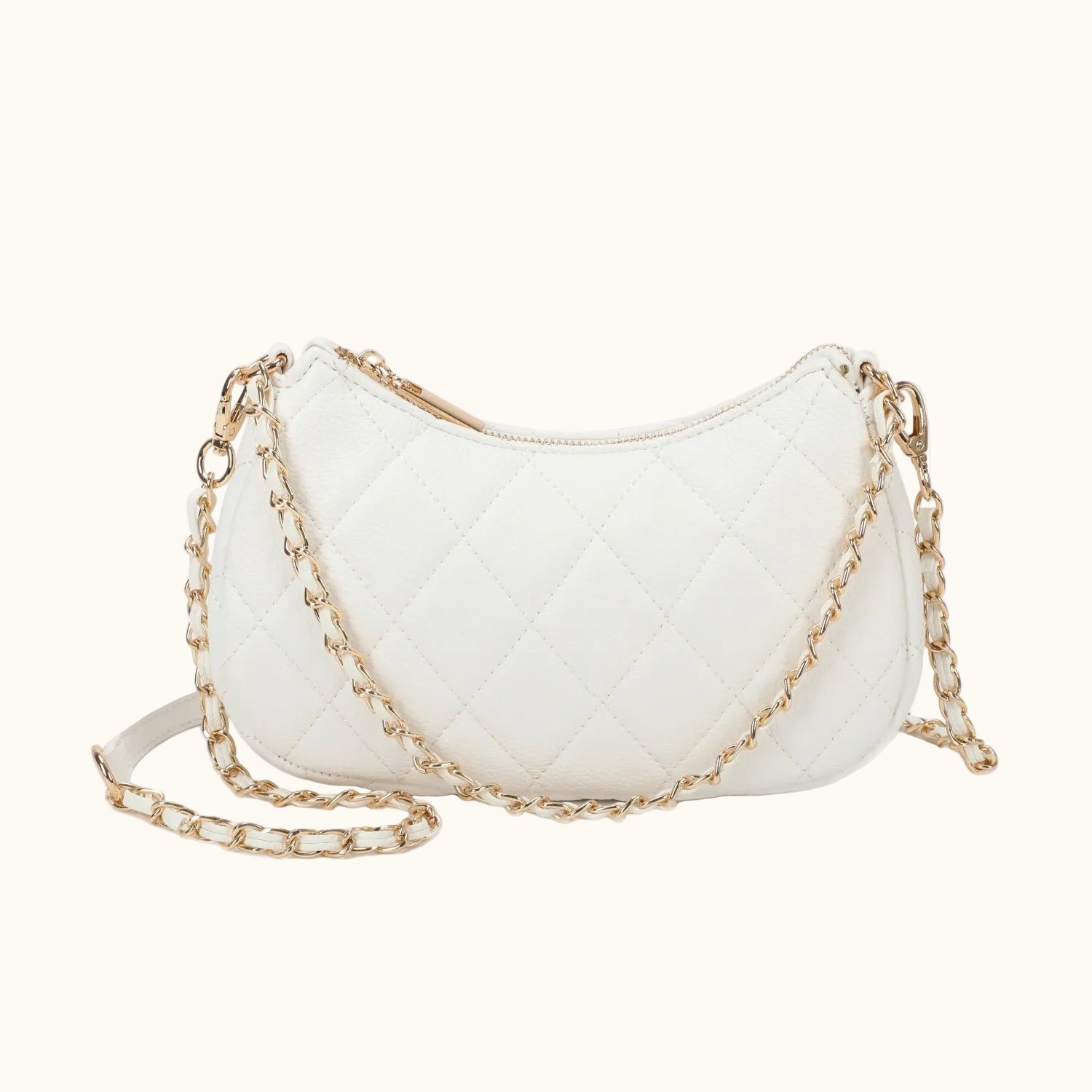 White quilted handbag with gold chain strap on a white background