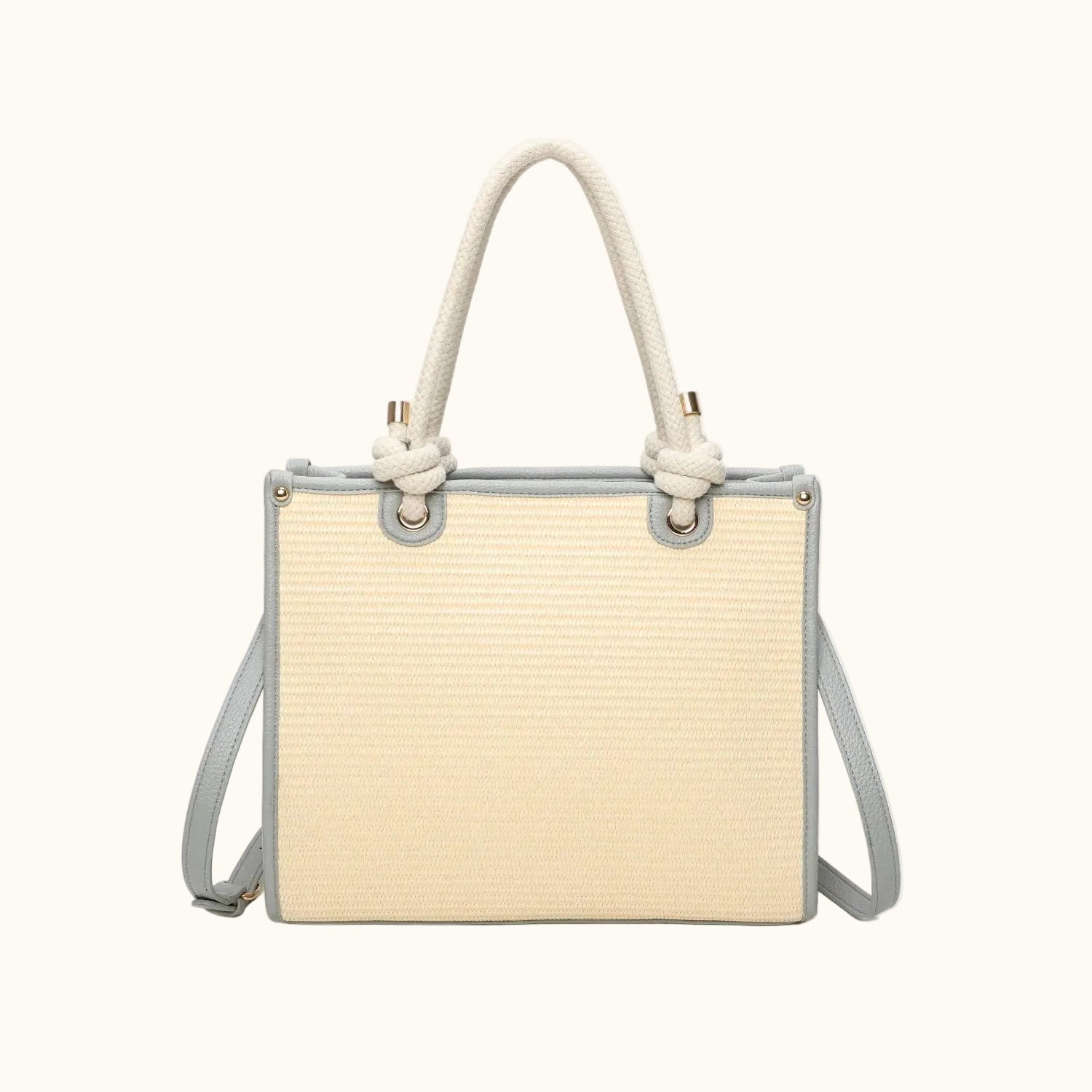 Beige handbag with rope handle and strap on a white background