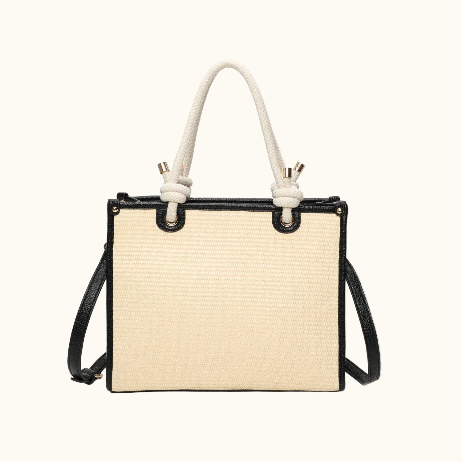 Beige handbag with black straps and white rope handles on a white background