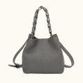 Gray handbag with perforated design and braided handle on a white background