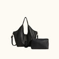 Black handbag and clutch on a beige surface with a neutral background