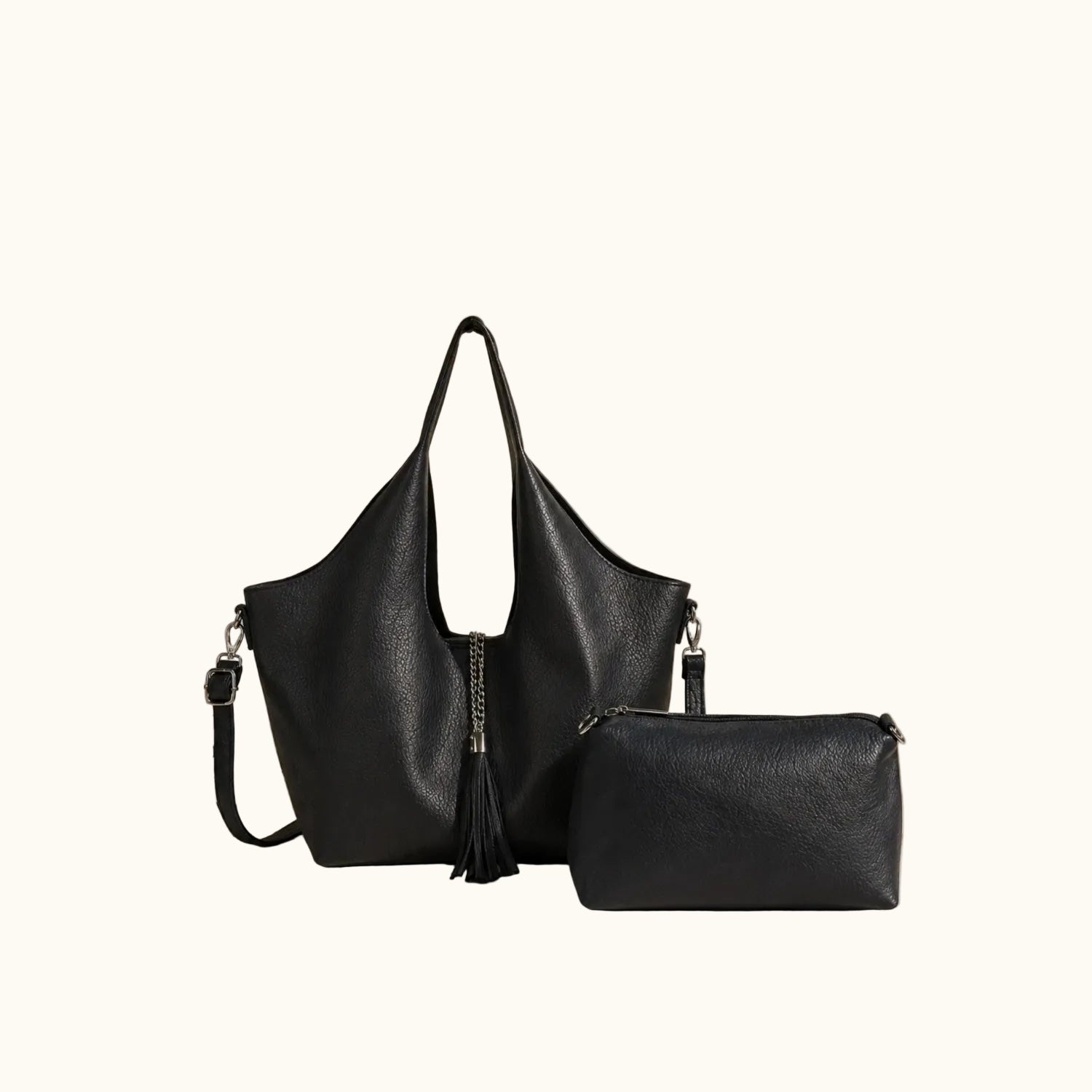Black handbag and clutch on a beige surface with a neutral background
