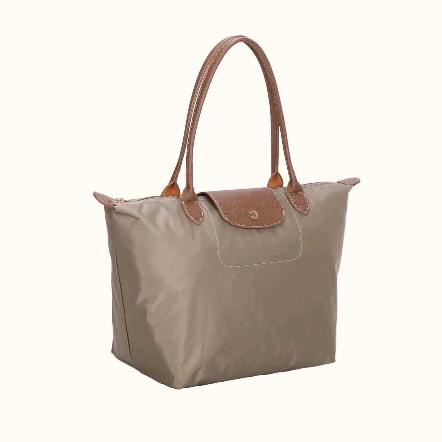 Beige tote bag with brown handles and trim on a white background