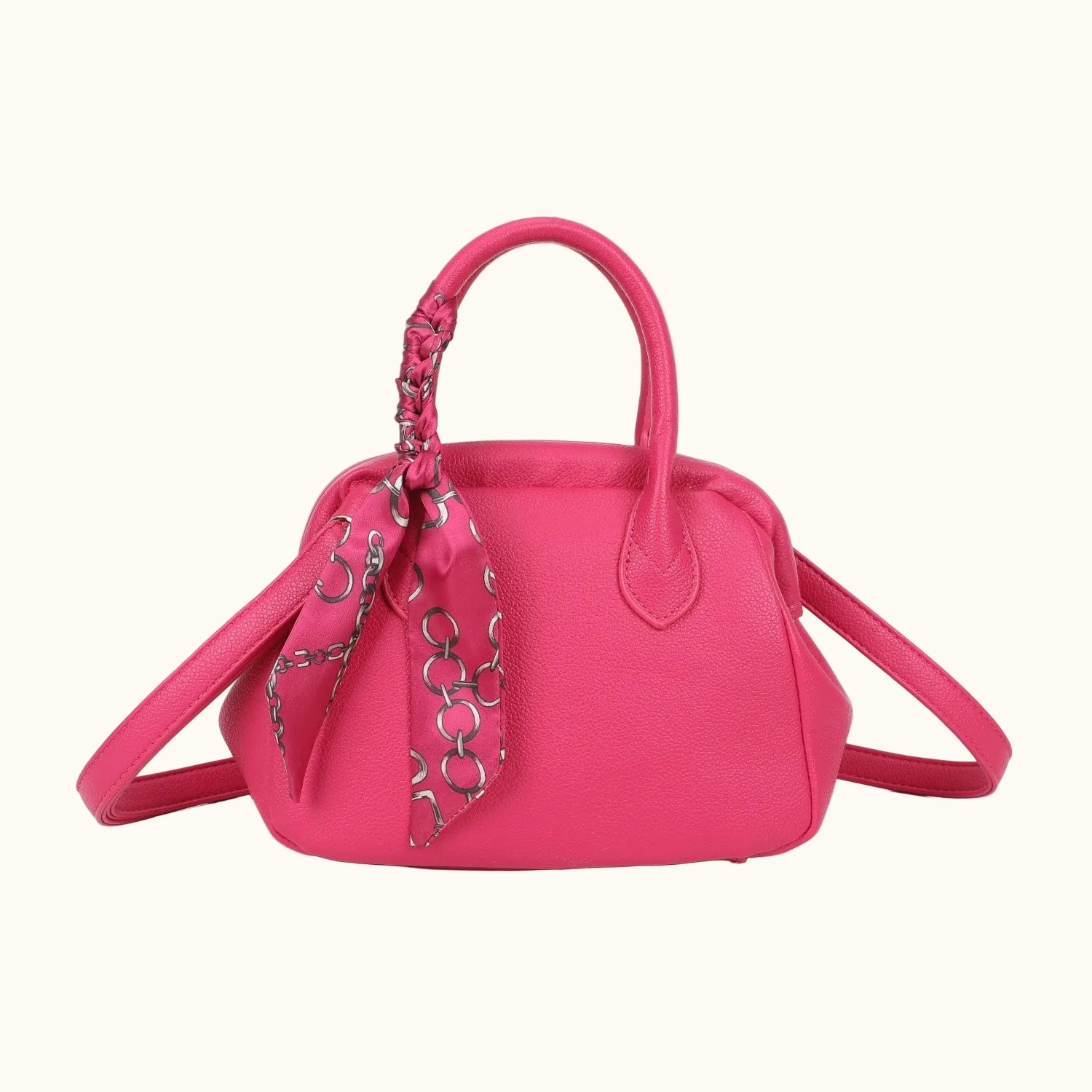 Pink handbag with a decorative strap on a white background