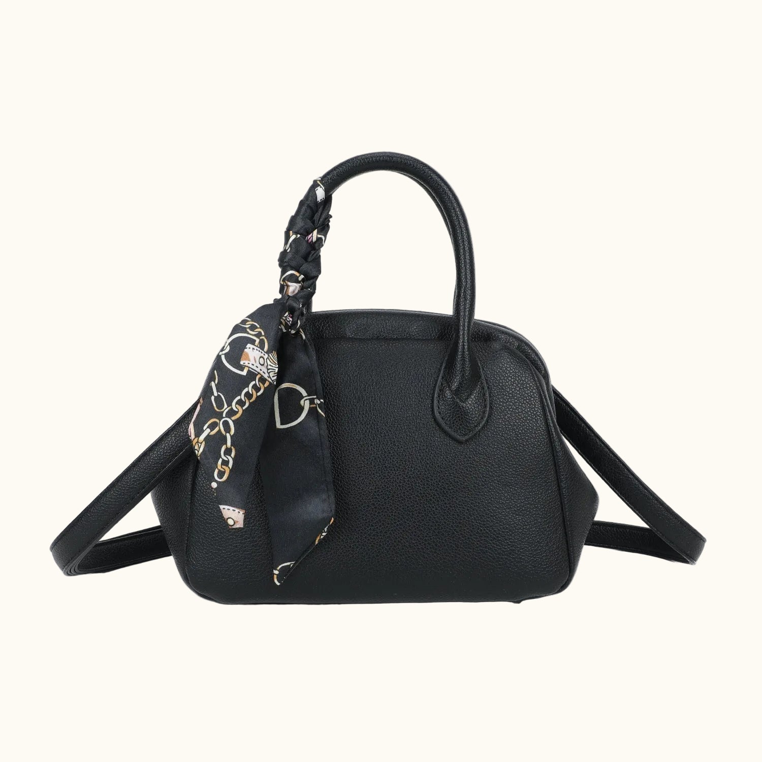 Black handbag with a matching scarf draped over it on a white background