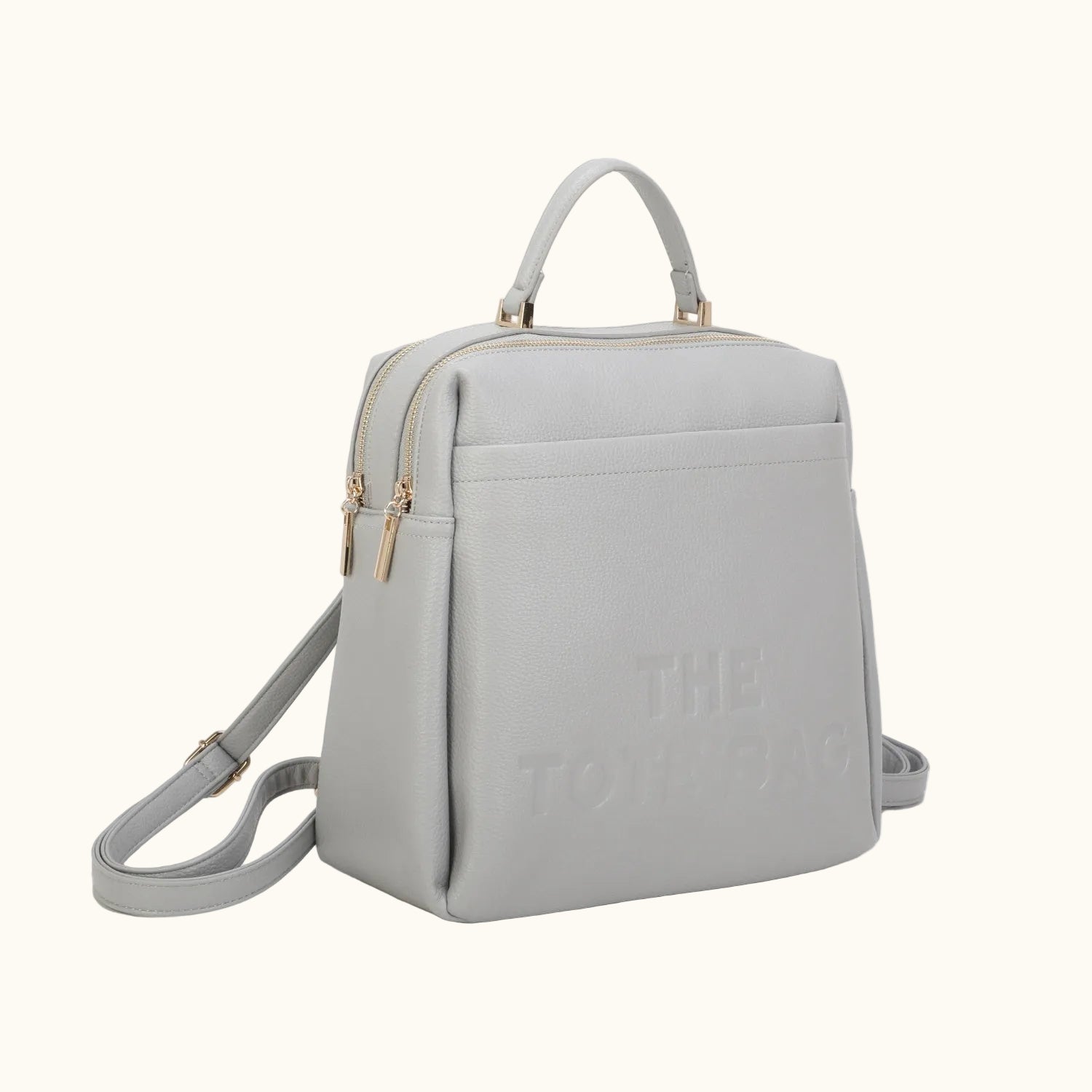 Light gray backpack with gold accents on a white background