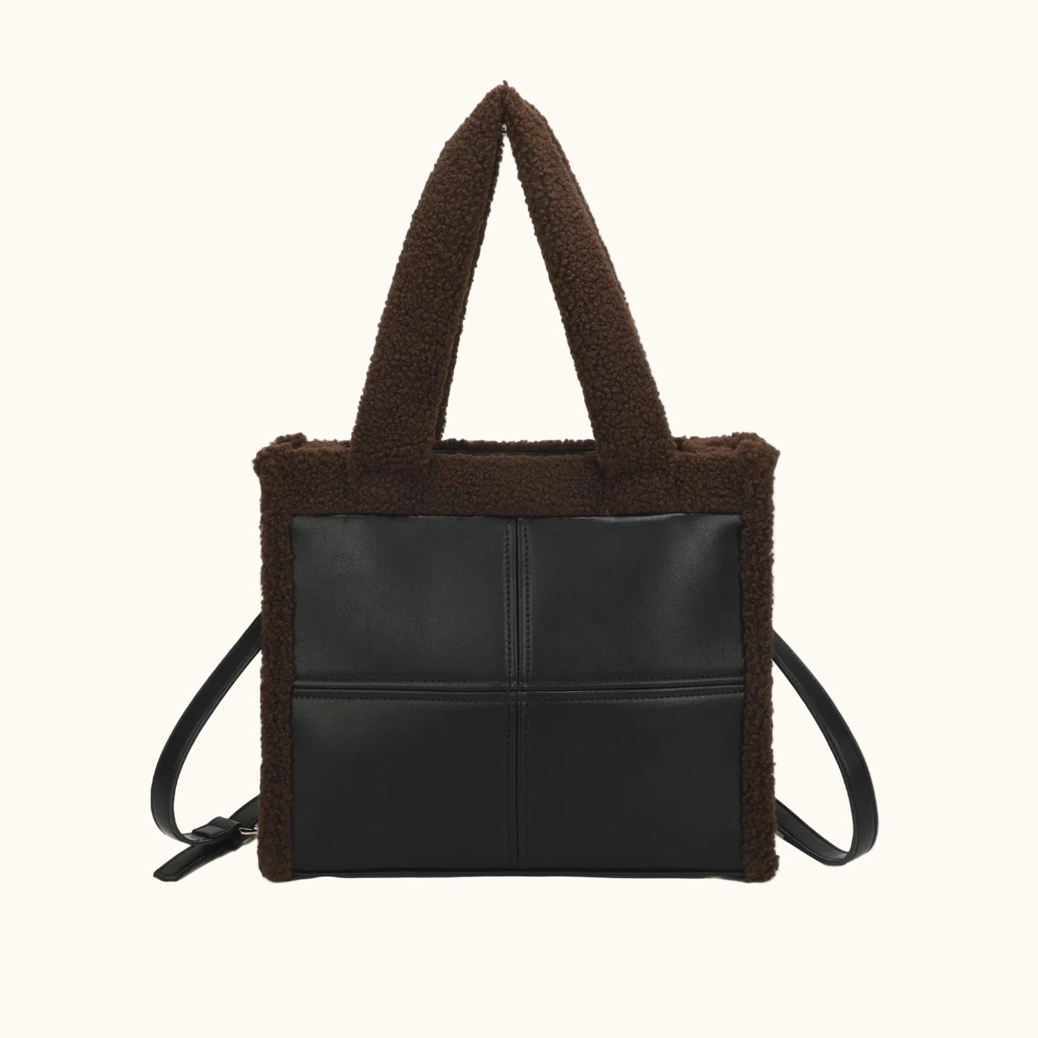 Black leather tote bag with brown shearling trim on a white background
