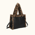 Black handbag with leopard print fur trim on a white background