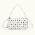 White handbag with silver studs on a white background