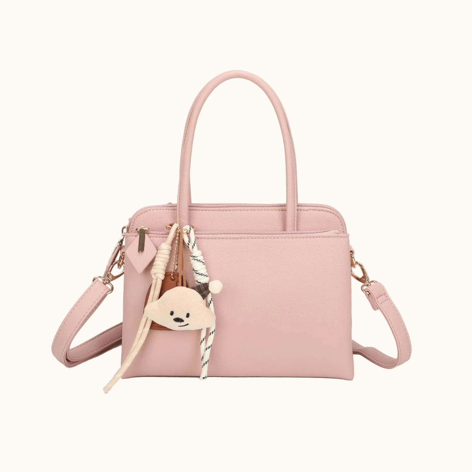 Pink handbag with decorative charms on a white background