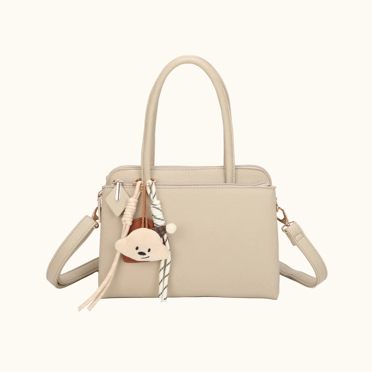 Beige handbag with a strap and decorative elements on a white background