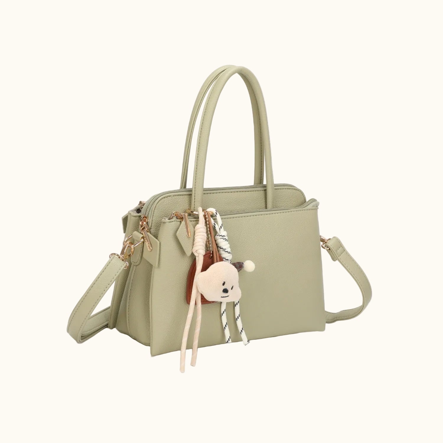 Light green handbag with a decorative charm on a white background
