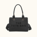 Black tote bag with 'THE TOTE BAG' text on a white background