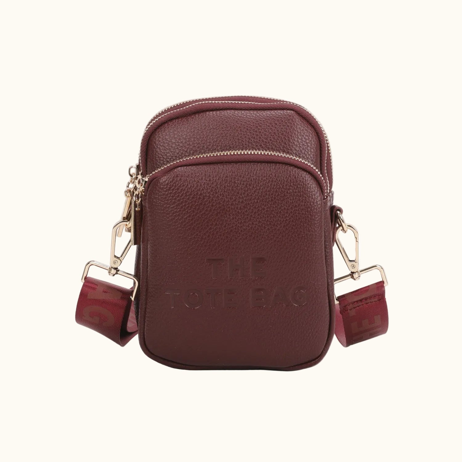Brown leather crossbody bag with gold accents on a white background