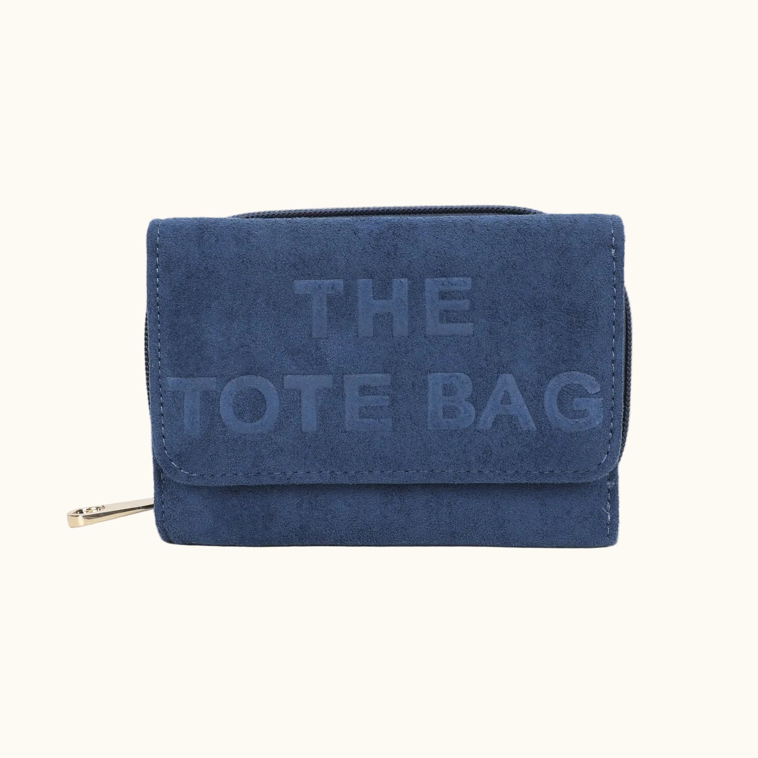 Blue suede wallet with 'THE TOTE BAG' embossed text on a white background