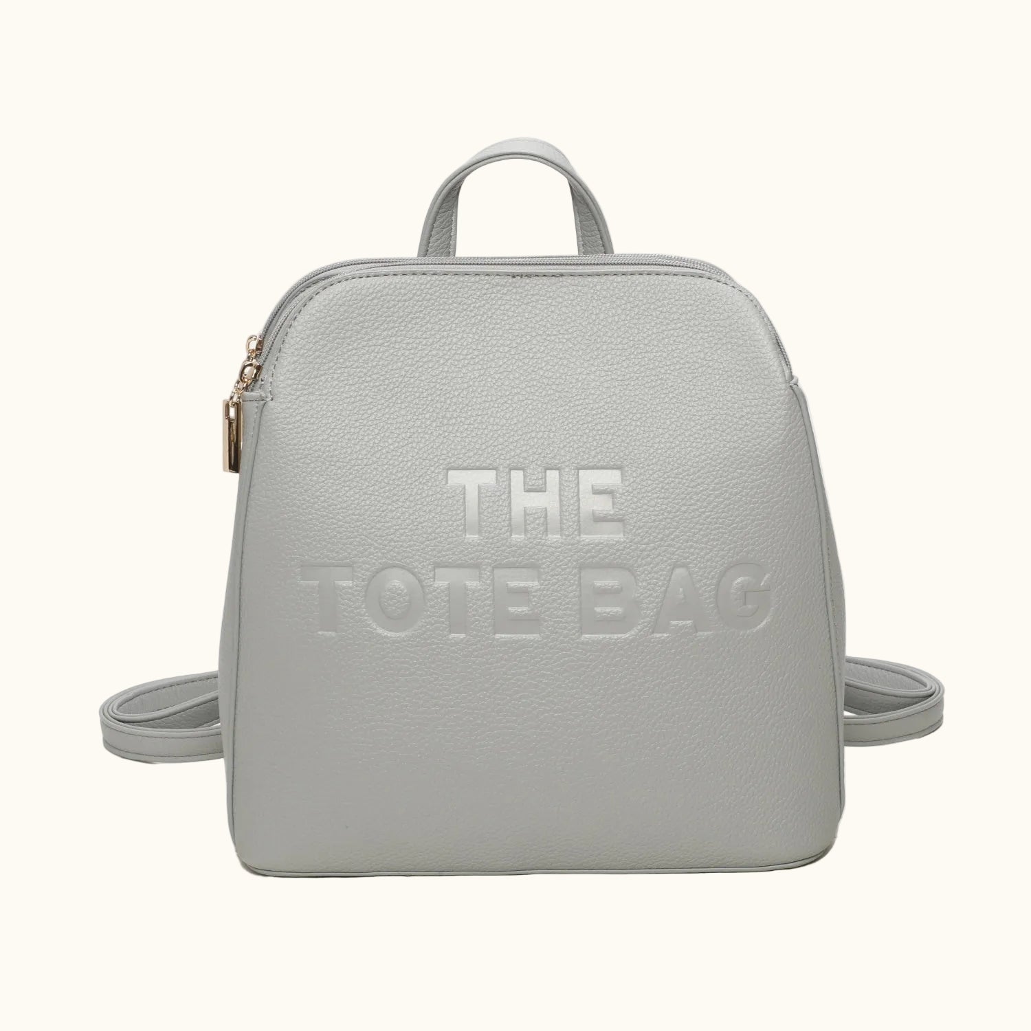 Light gray backpack with 'THE TOTE BAG' text on a white background