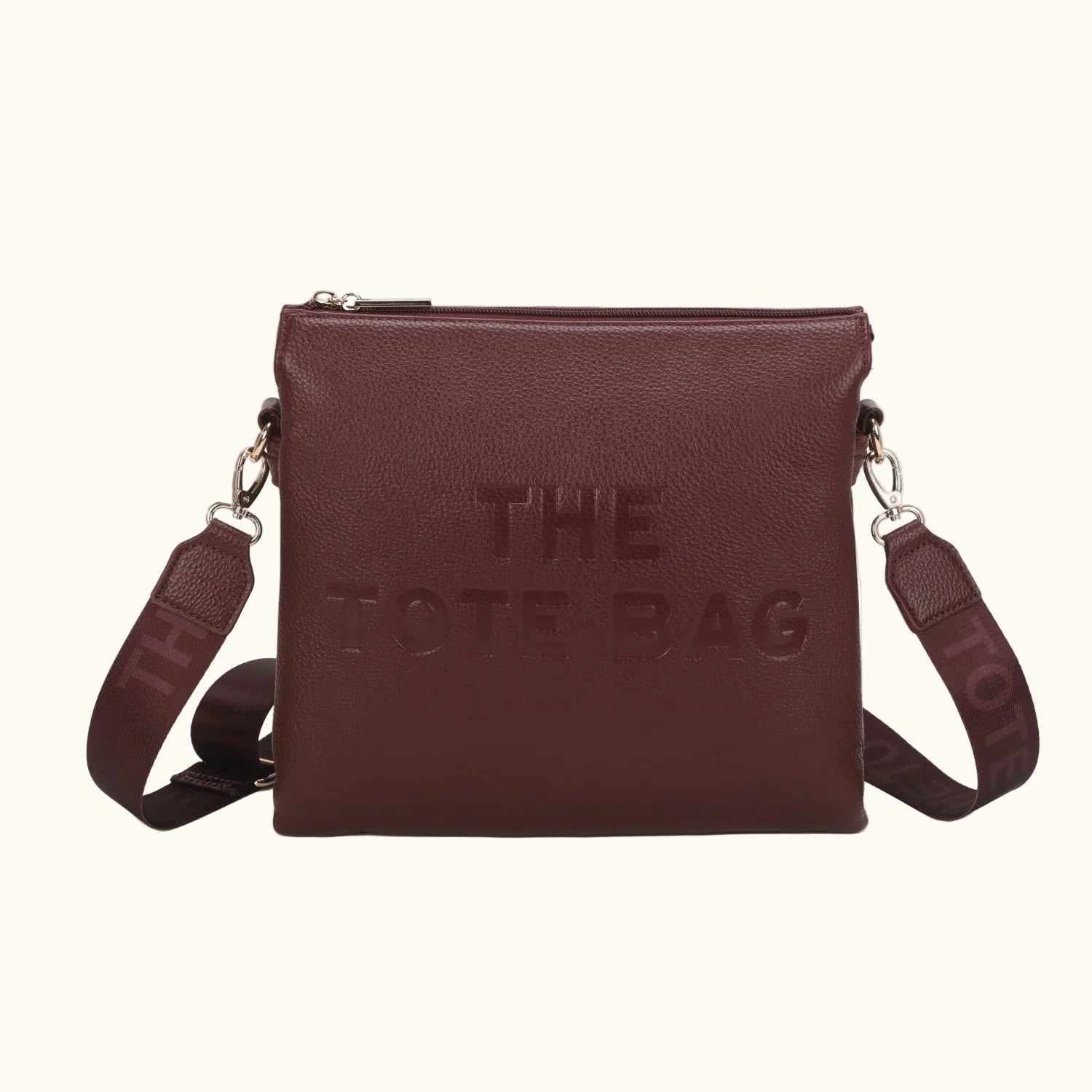 Brown leather tote bag with 'THE TOTE BAG' text on a white background