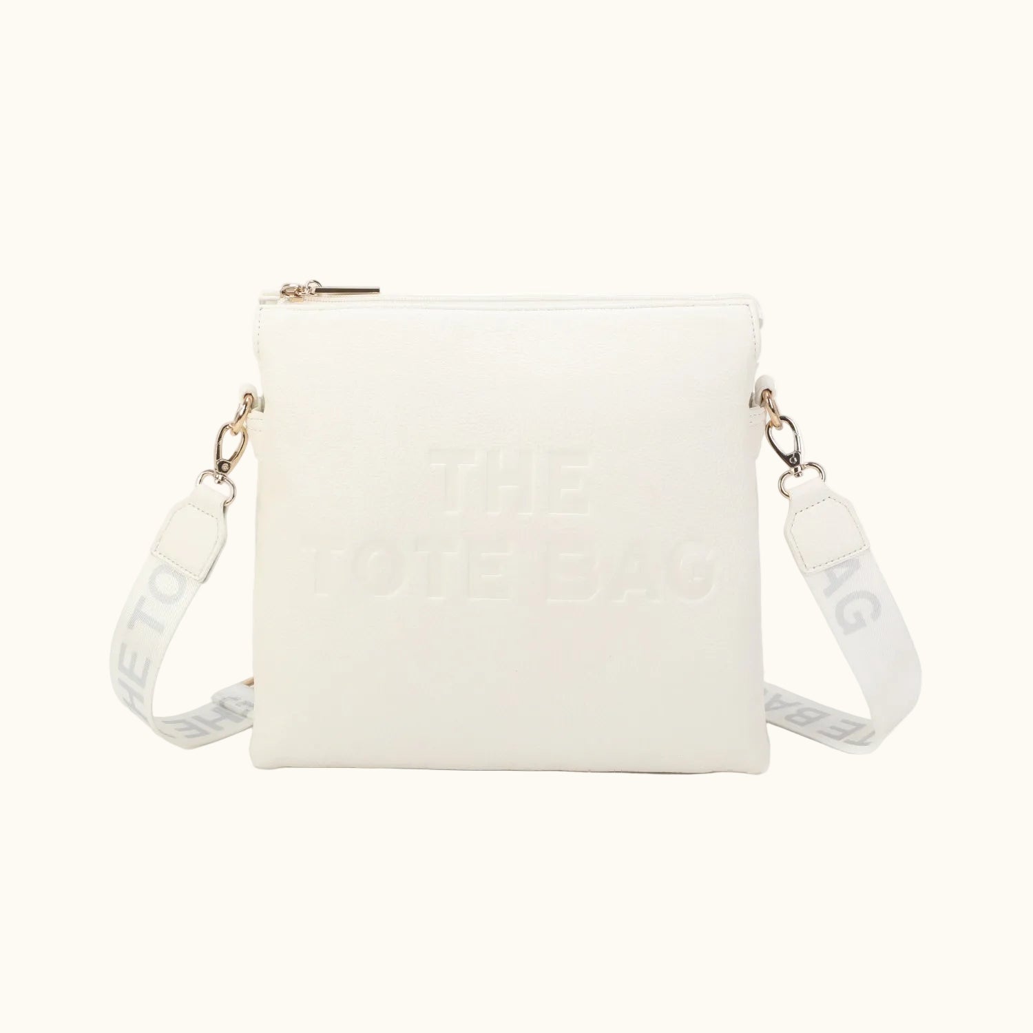 White crossbody bag with gold accents on a white background